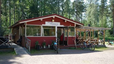 Kuva Vilniemen Kyläpirtistä, jossa näkyy rakennus edestä päin. Tilava terassi ja liikkumista helpottava ramppi.